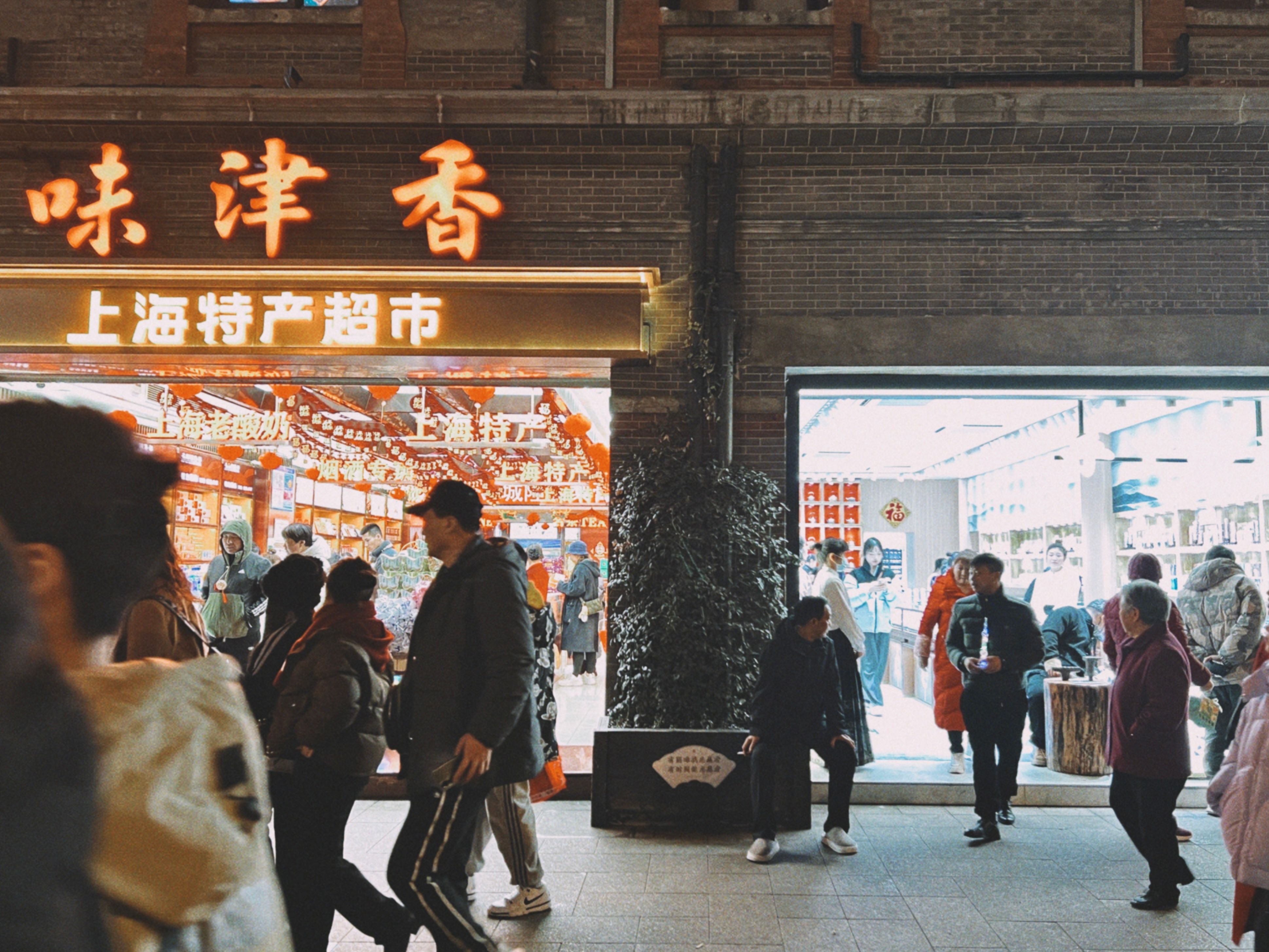 Vibrant evening street scene outside a Shanghai store with pedestrians and city lights.