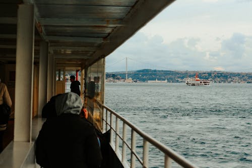 A person sitting on the deck of a ferry looking out at the water