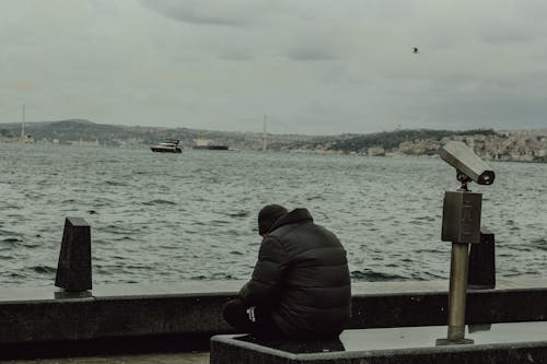 A man sitting on a bench looking out over the water