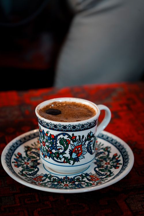 Free Close-up of a decorated porcelain cup containing espresso on a matching saucer. Stock Photo