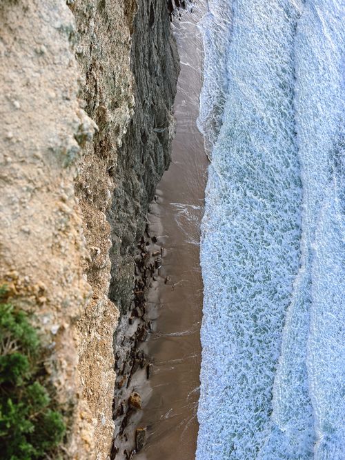 Free Aerial view of the stunning cliffside in Ericeira, Portugal with waves crashing on the shore. Stock Photo