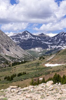 Snow-capped Rocky Mountains with lush alpine valley and dramatic sky in Breckenridge, Colorado.