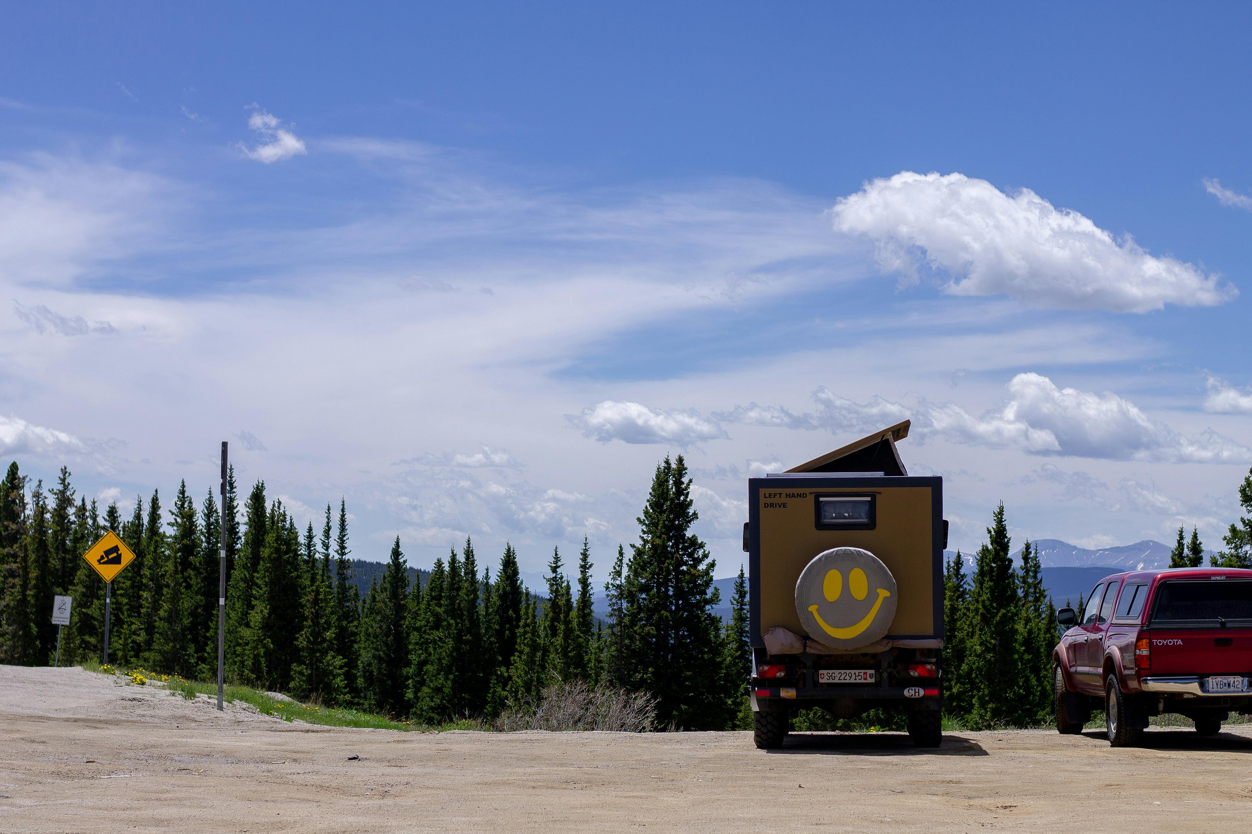 camper van with smiley face on treeline