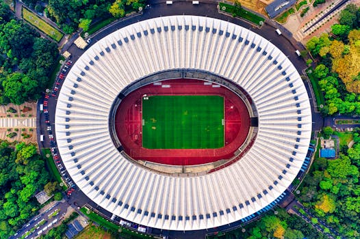 Drone shot of Gelora Bung Karno Stadium, showcasing its distinctive architecture and surrounding greenery.