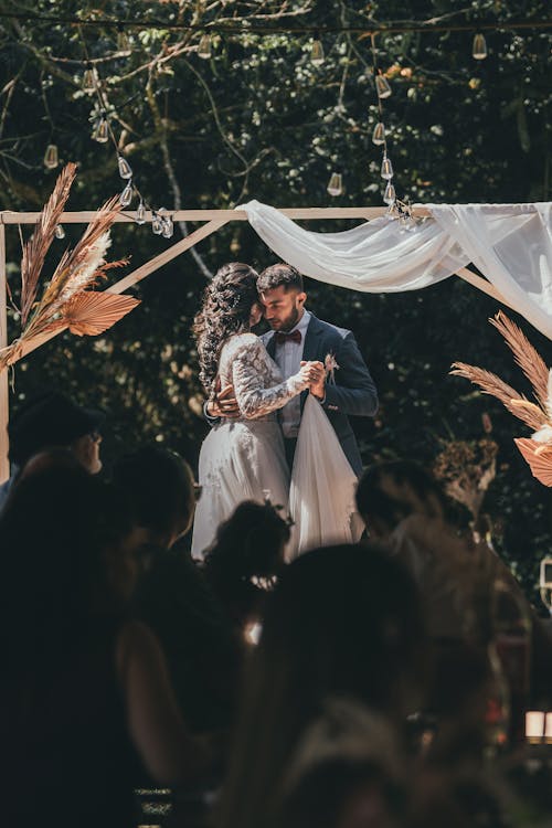 A couple kissing under an arbor at their wedding