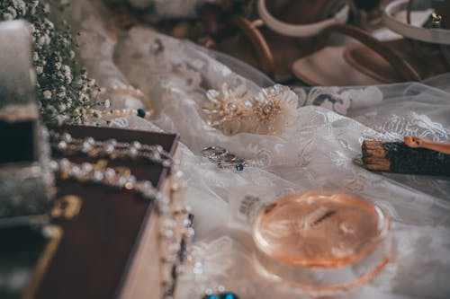 A wedding dress and accessories are laid out on a bed