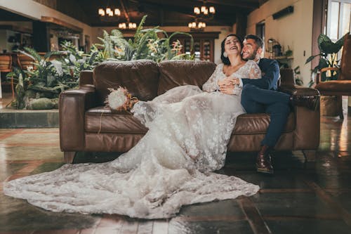 A bride and groom sitting on a couch in a room