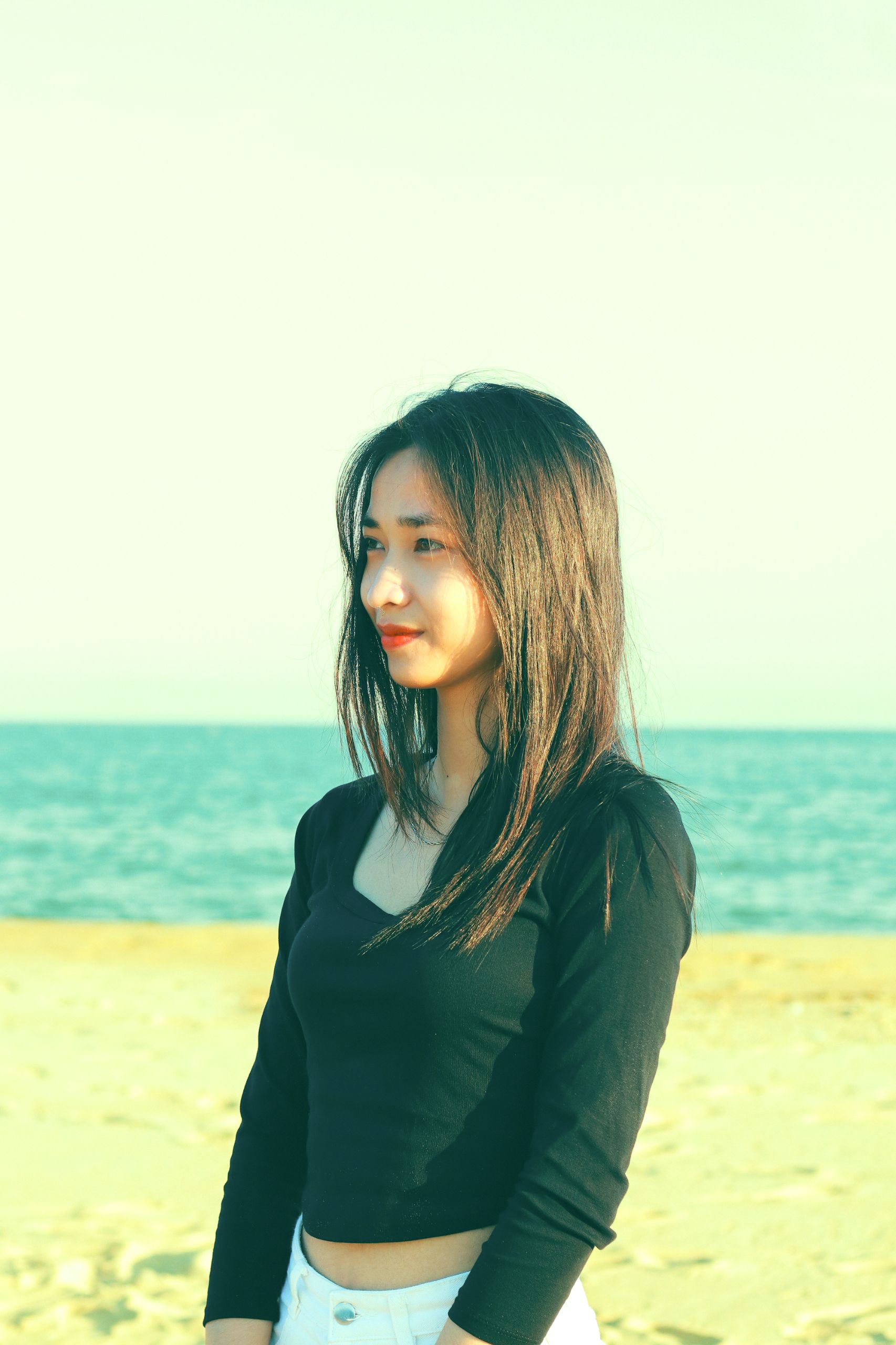 A Young Girl Standing on a Beach · Free Stock Photo