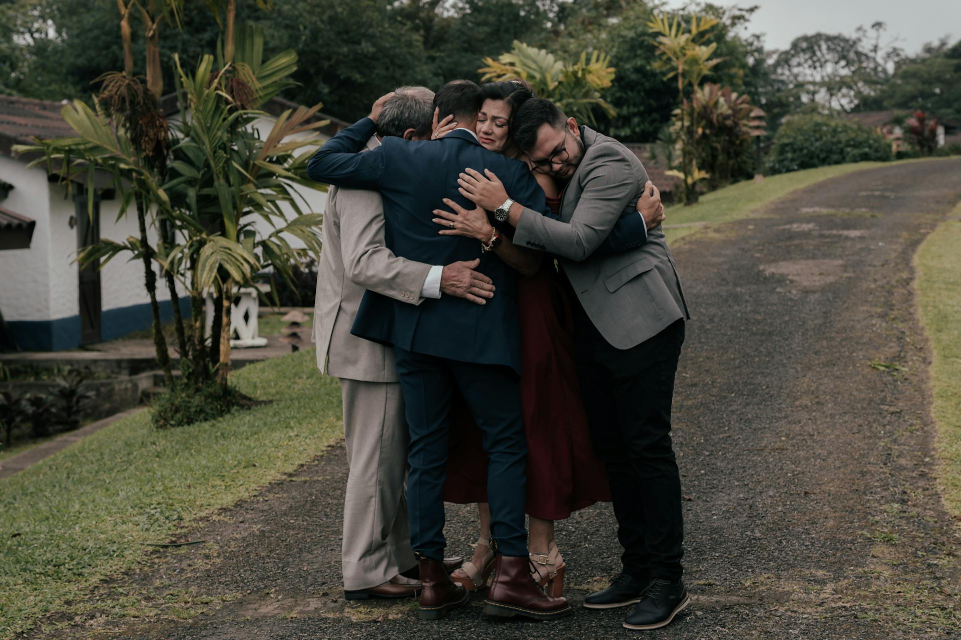 A Group of People in Elegant Clothes Hugging in a Park