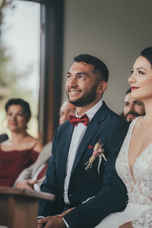 A man and woman are smiling at each other during their wedding ceremony