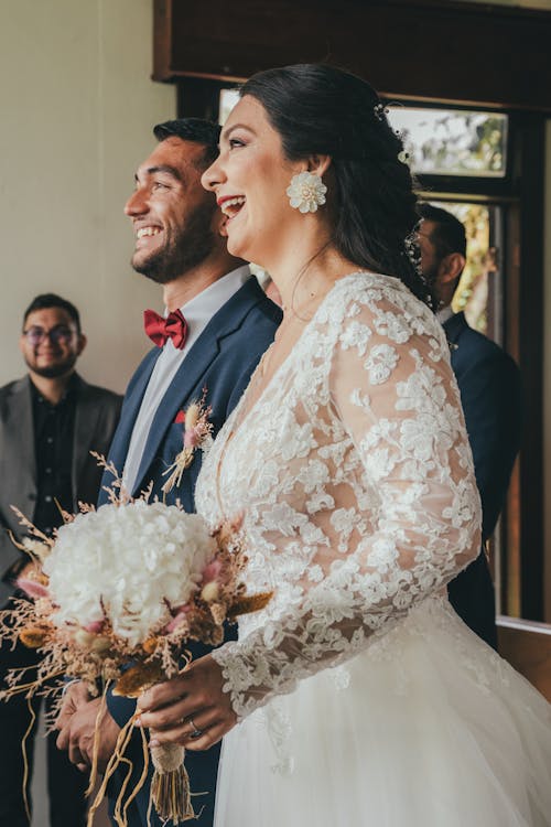 A bride and groom smile as they walk down the aisle