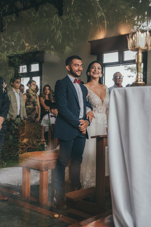 A bride and groom are standing at the altar