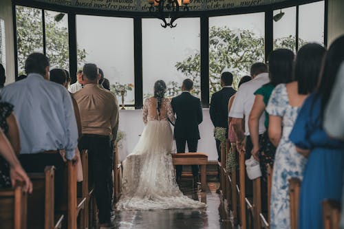 A bride and groom walk down the aisle at a church