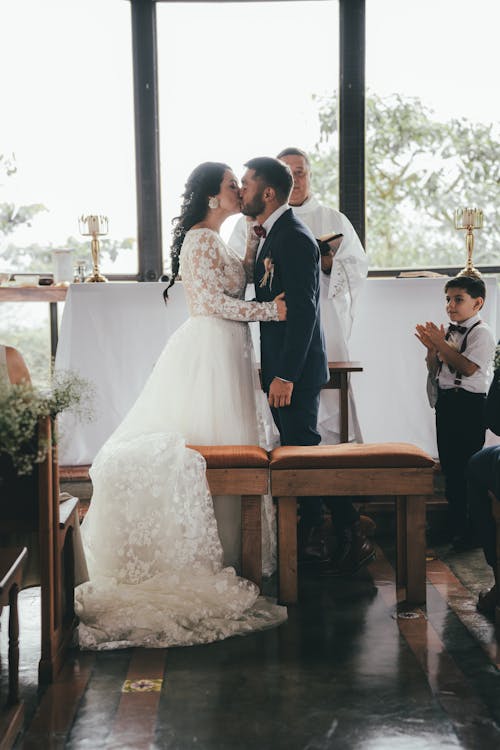 A bride and groom kiss in front of a church