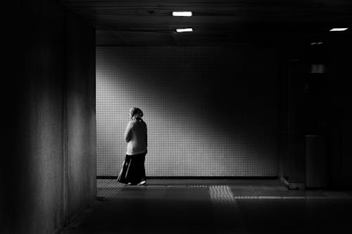 A woman walking down a dark tunnel