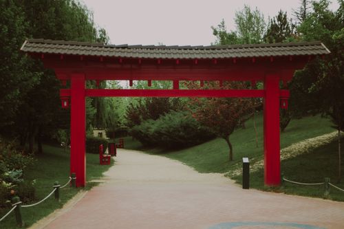Free A picturesque torii gate surrounded by lush greenery in a tranquil Japanese garden. Stock Photo