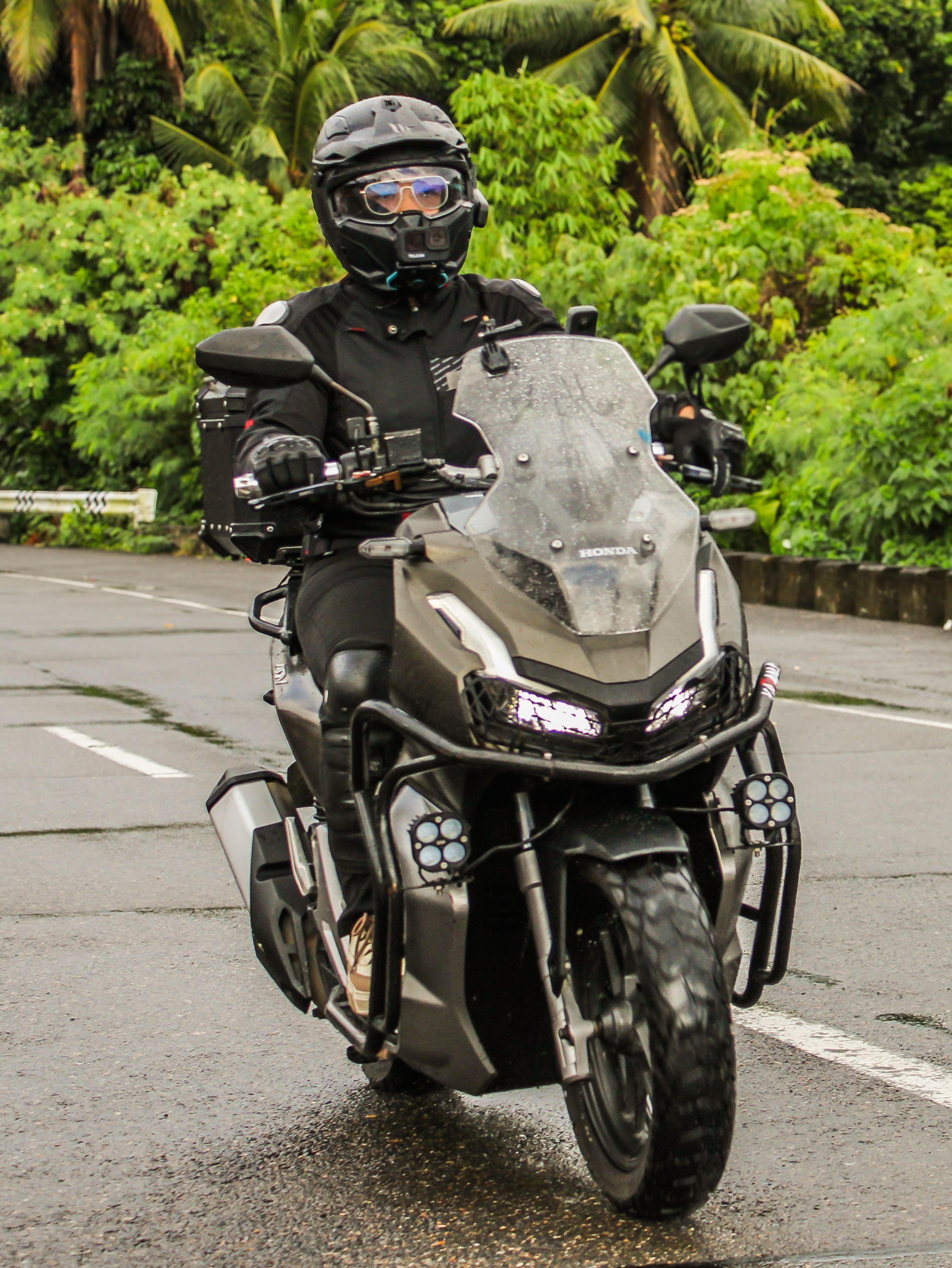 A man in black riding a motorcycle on a rainy day · Free Stock Photo