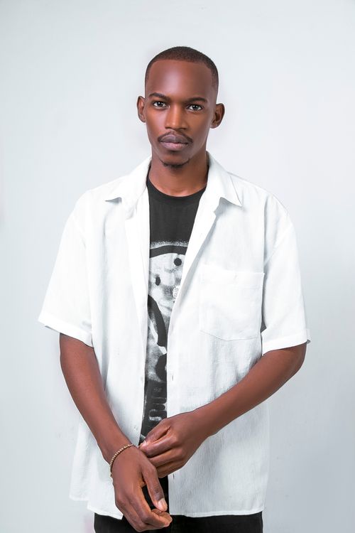 Free A cool and contemporary portrait of a young man wearing a stylish white shirt and black graphic tee. Stock Photo