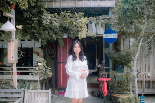 A woman in white dress standing outside a restaurant