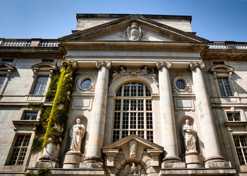 Free Statues adorn the neoclassical facade of Humboldt University in Berlin, Germany. Stock Photo