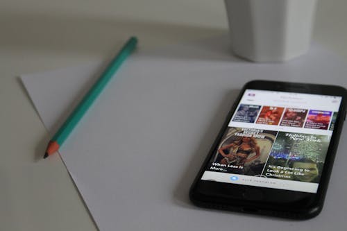 Iphone Negro Encendido Que Muestra Una Foto En El Papel De La Impresora Junto Al Lápiz