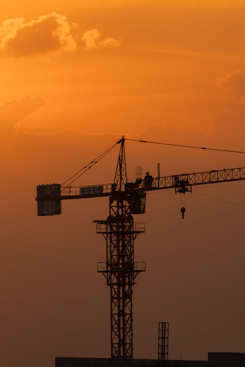 A crane is silhouetted against the sunset