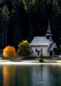 秋色倒映水中，特伦蒂诺-南蒂罗尔州湖边的石教堂宁静伫立