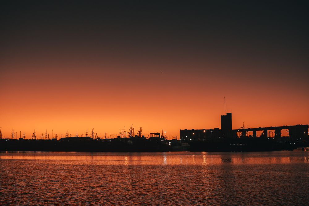 Container ship loading at international port at golden hour