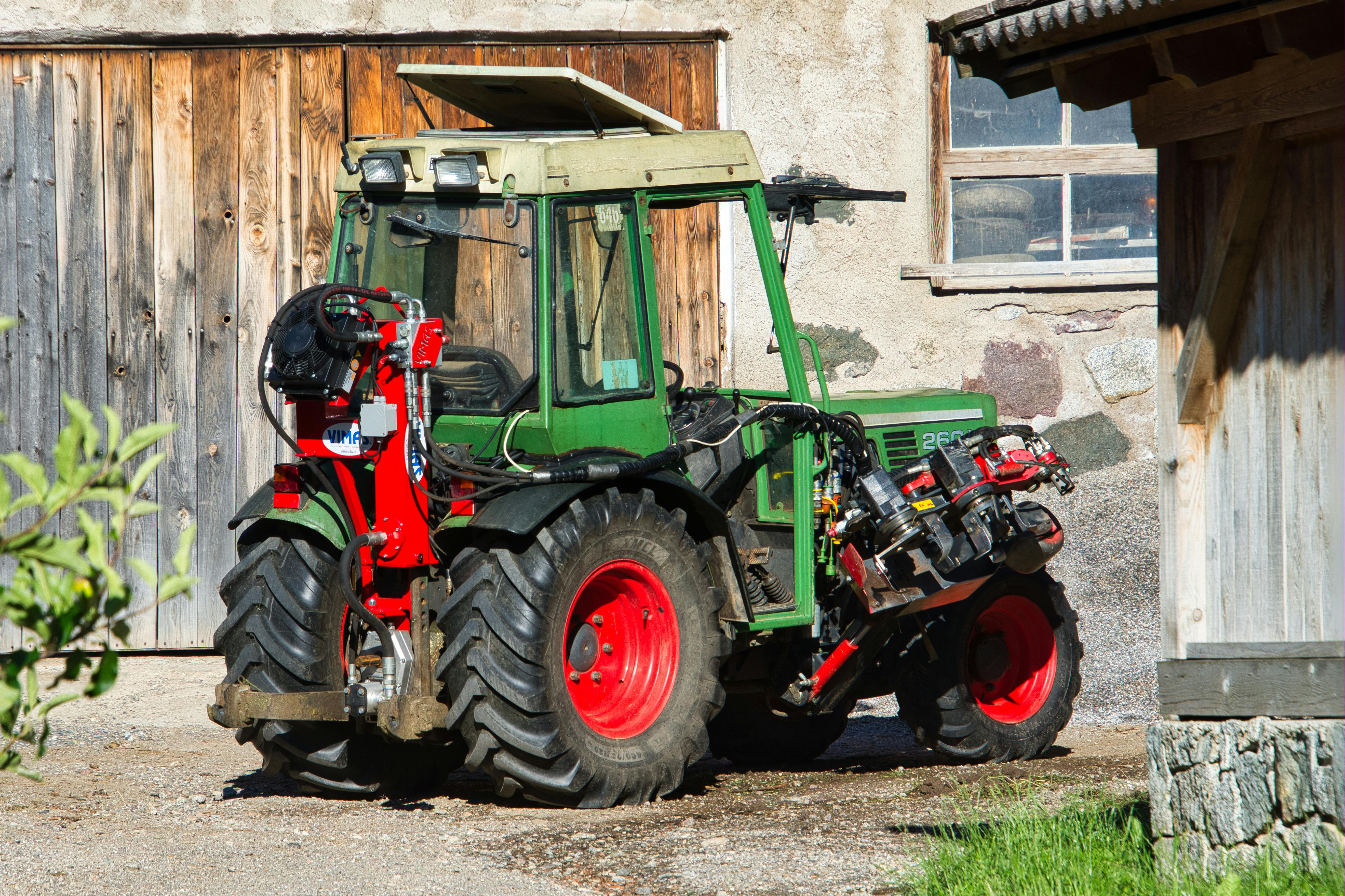 Close-up of a green tractor parked on a sunny farmyard in Schenna, Trentino-Südtirol.