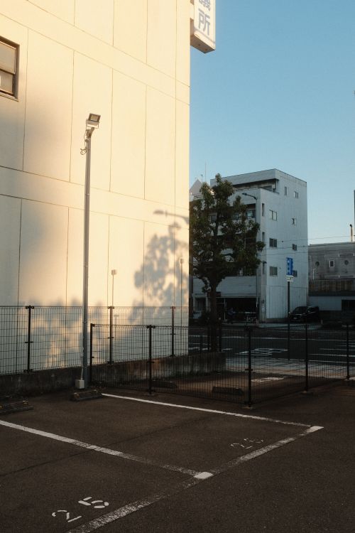 Free An urban parking lot with minimalistic buildings captured at sunset. Stock Photo