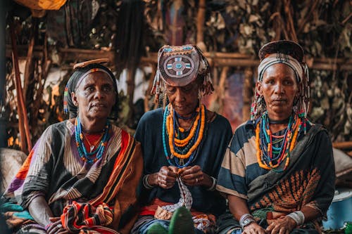 Three women wearing traditional clothing sit together