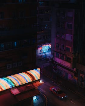 High angle view of a city street with neon lights at night, capturing urban vibe.