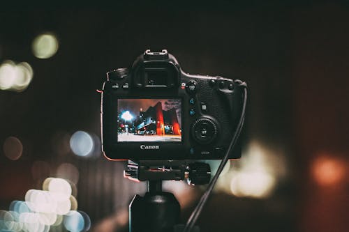 Fotografi Fokus Selektif Kamera Canon Hitam Menampilkan Foto Gedung Merah Dan Hitam