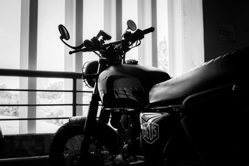 Free A stylish motorcycle parked indoors with a classic black and white theme. Stock Photo