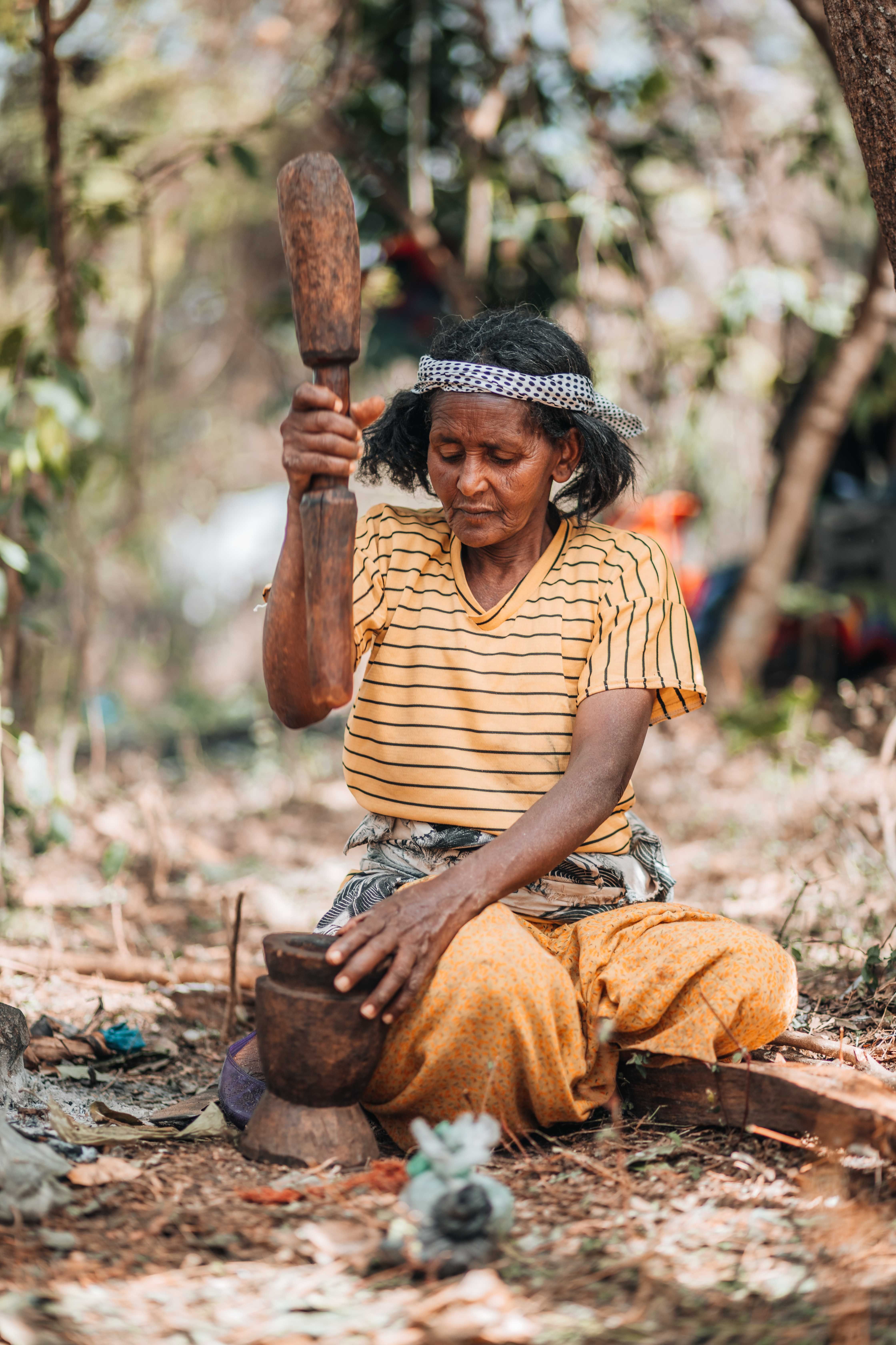 Woman Using Wooden Mortar and Pestle under Tree · Free Stock Photo