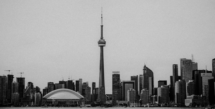 A black and white view of Toronto's skyline featuring the iconic CN Tower and modern architecture.