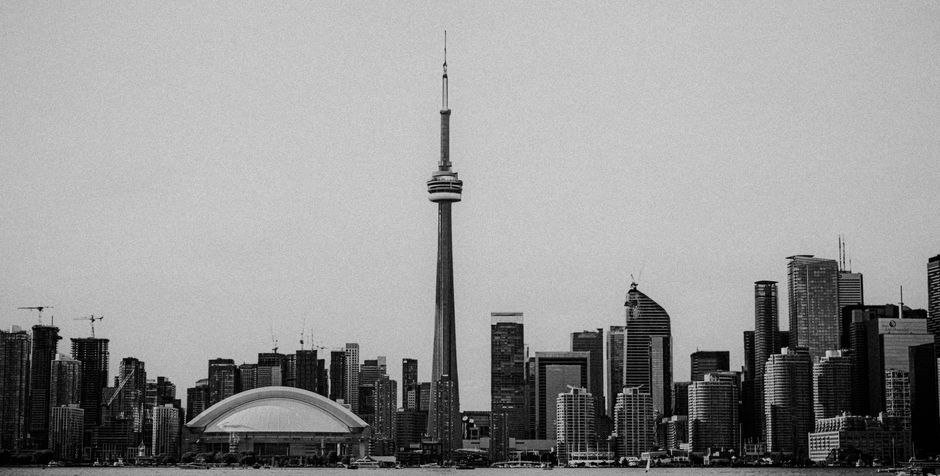 A black and white view of Toronto's skyline featuring the iconic CN Tower and modern architecture.