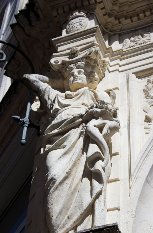 Free Detailed stone sculpture on historic building facade capturing intricate architectural artistry. Stock Photo
