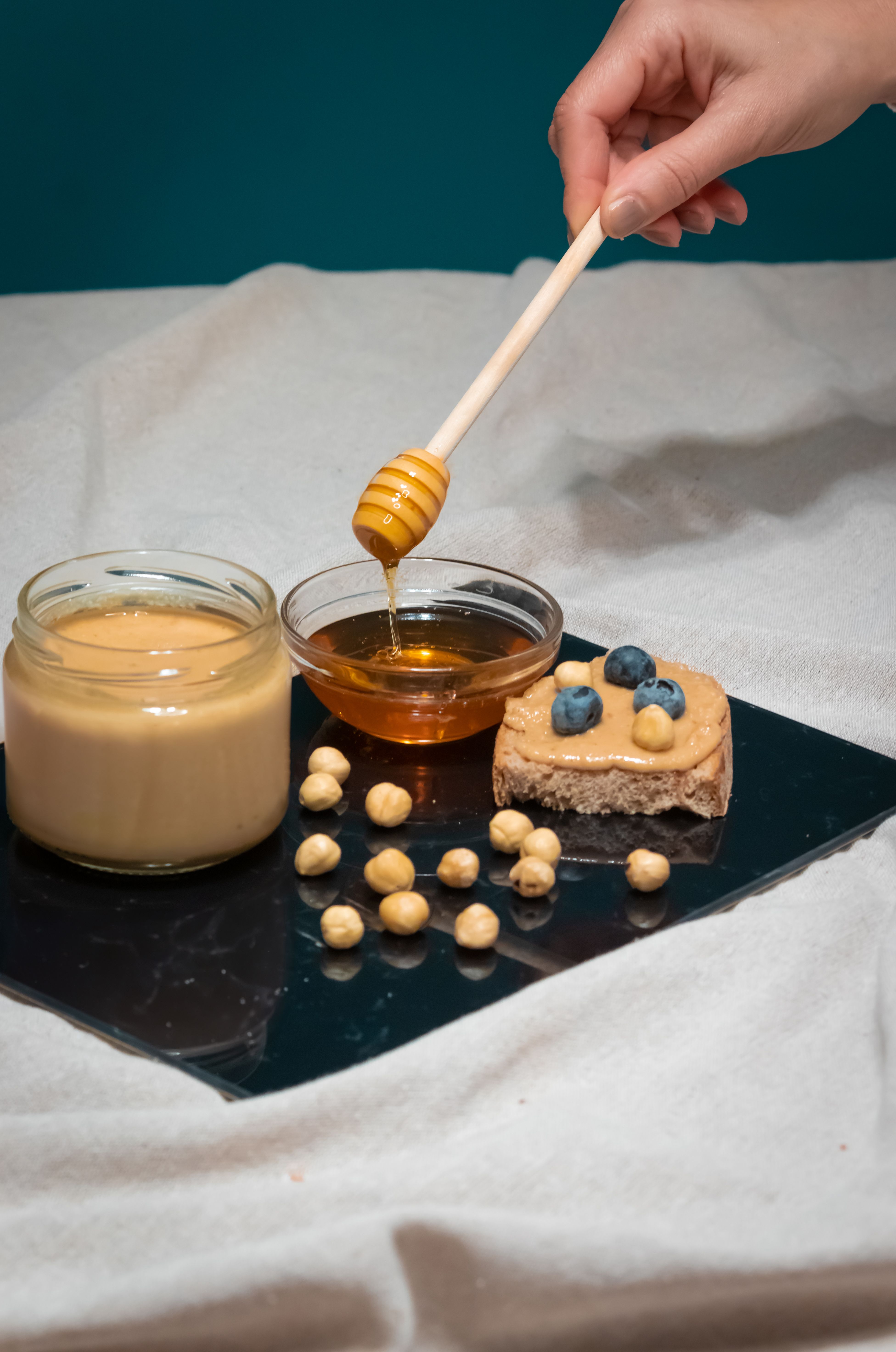 A close-up shot of toast with hazelnut butter, honey, and blueberries, set in İzmir.