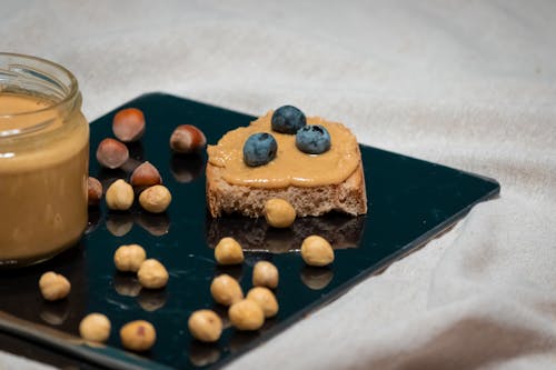 A plate with peanut butter and blueberries