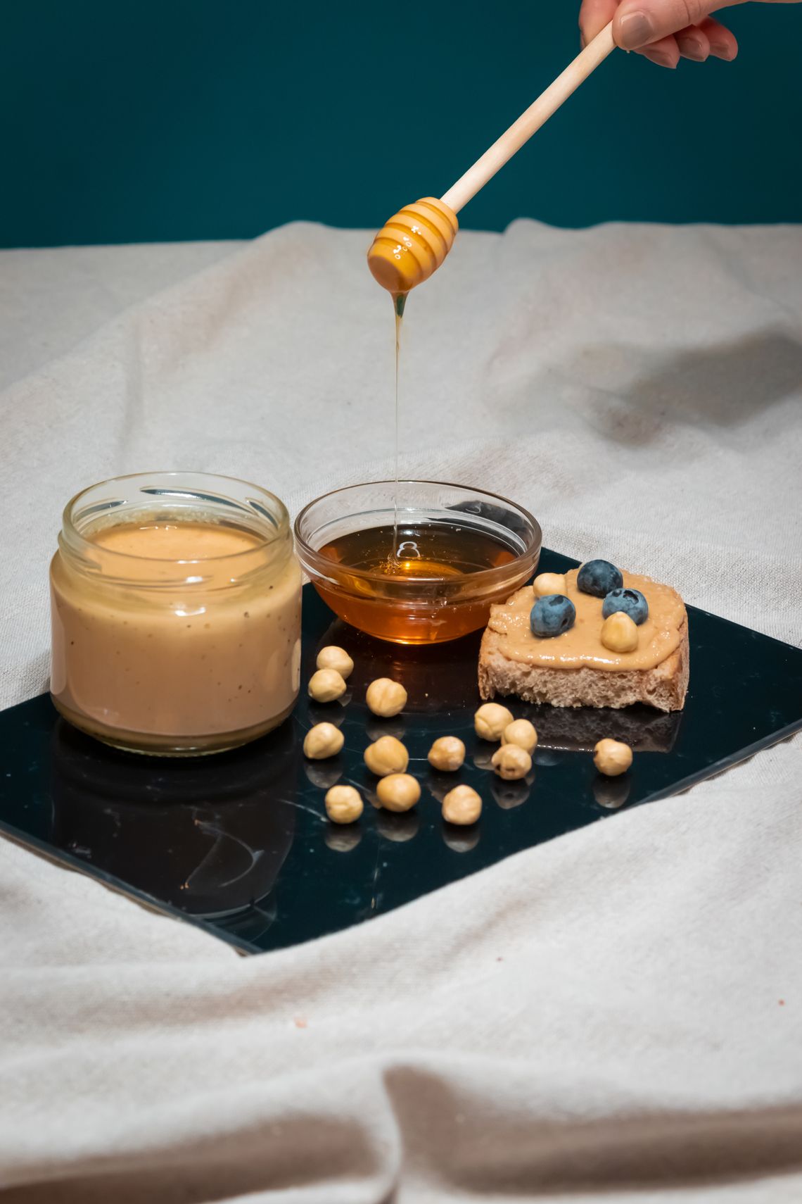 Nut butter, honey, blueberries, and rustic bread arranged as a real pantry snack