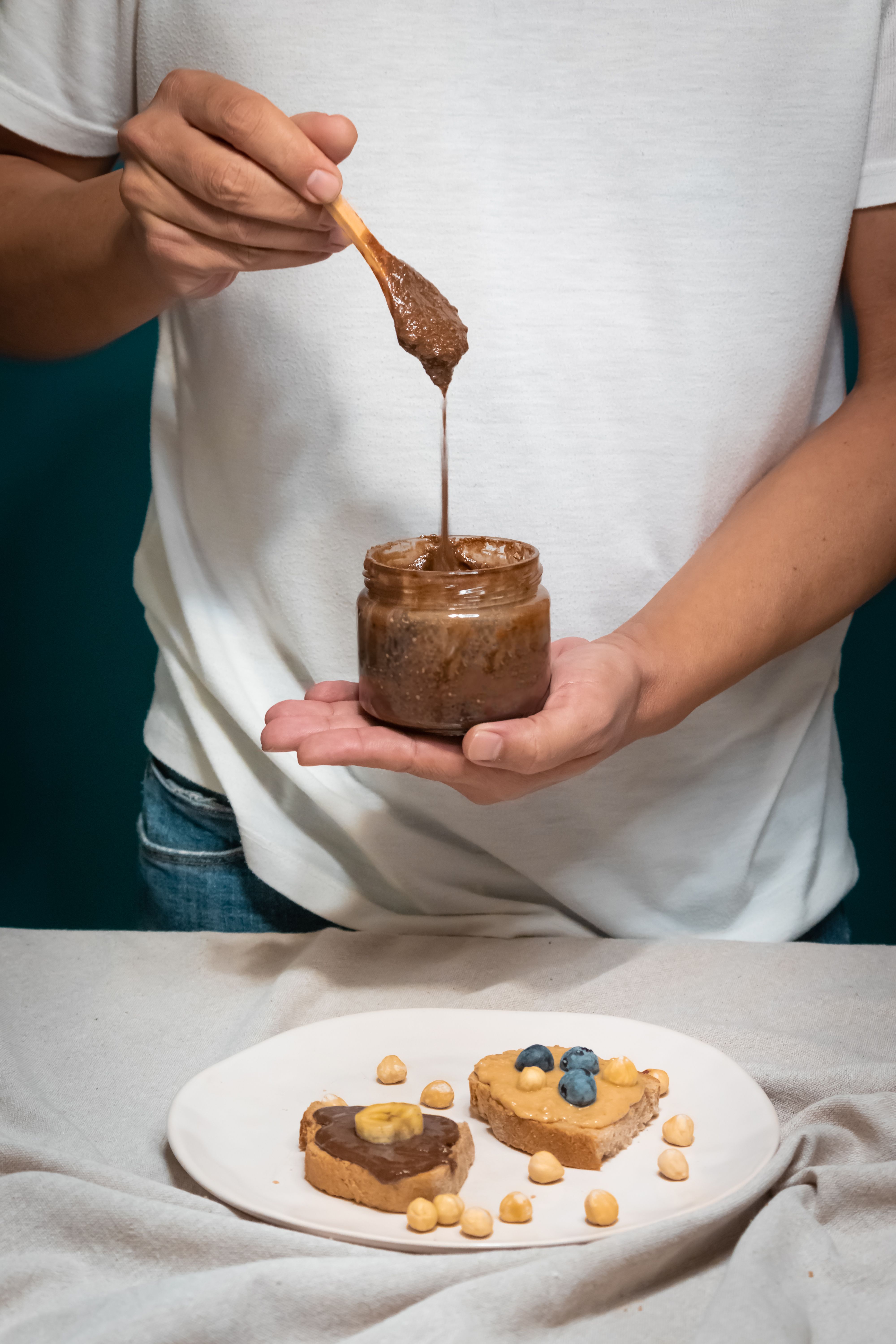 Man spreading chocolate cream on hazelnut and blueberry toast in Izmir.