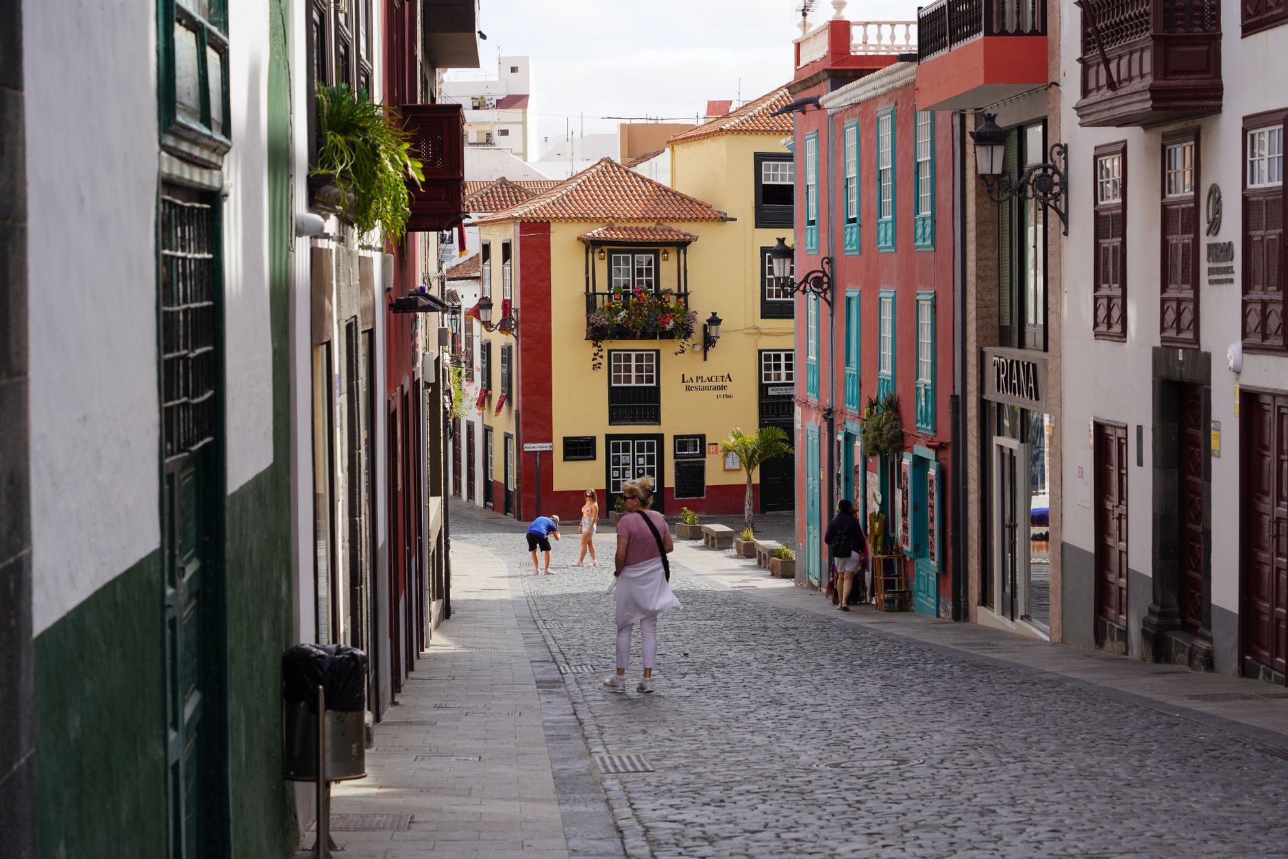 Inviting street scene with vibrant buildings and pedestrians on a cobblestone path.