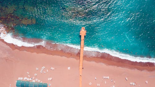 Aerial view of a beach with a red lighthouse