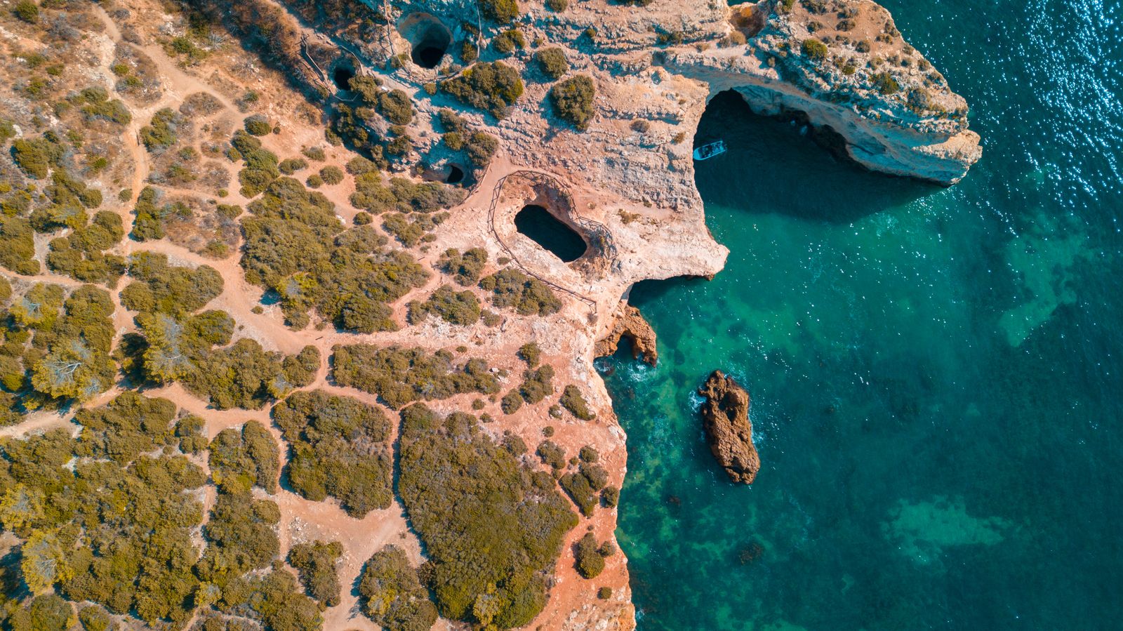 Algarve rock formations sea caves aerial Portugal orange cliffs
