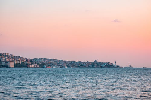 A sunset over the water with a city in the background