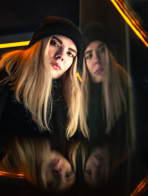 無料 ガラスの壁の反射と黒のニット帽を身に着けている女性 写真素材