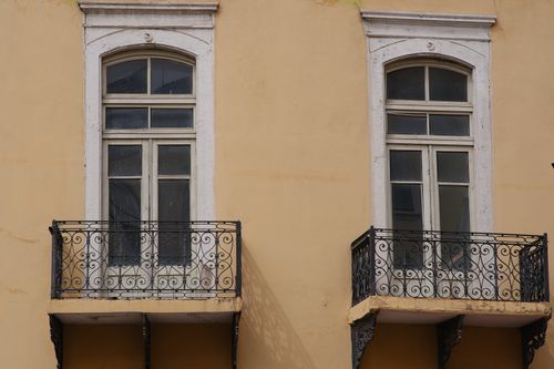 Free Elegant twin balconies on a beige building facade in Izmir, Turkey, showcasing intricate ironwork. Stock Photo