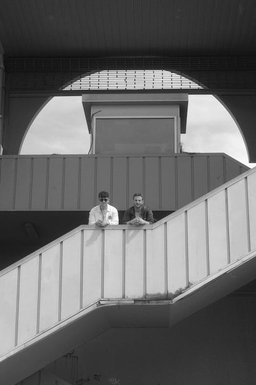 Two men are sitting on the stairs of a building