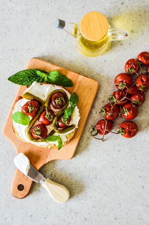 A cutting board with tomatoes, basil and cheese